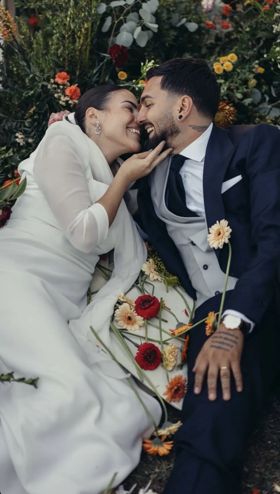 Novios abrazados entre flores