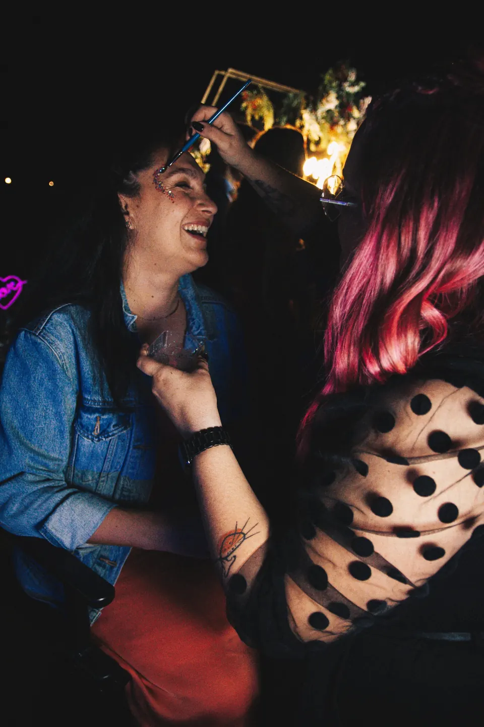 Glitter corner: maquilladora aplicando purpurina a una invitada en la fiesta