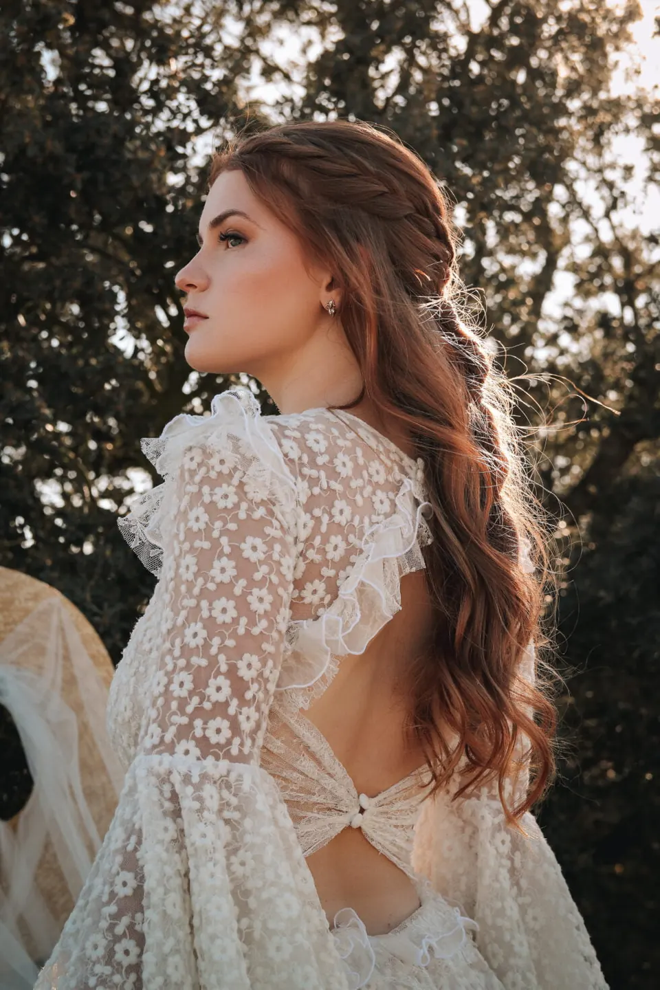 Novia de espaldas con el pelo suelto ondulado y vestido de encaje