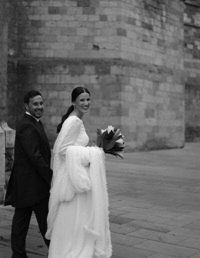 Novios de la mano y sonriendo mirando hacia atrás