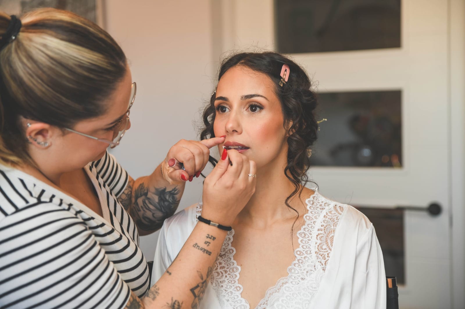 Productos imprescindibles para retocar tu maquillaje en eventos Maquilladora trabajando con una novia