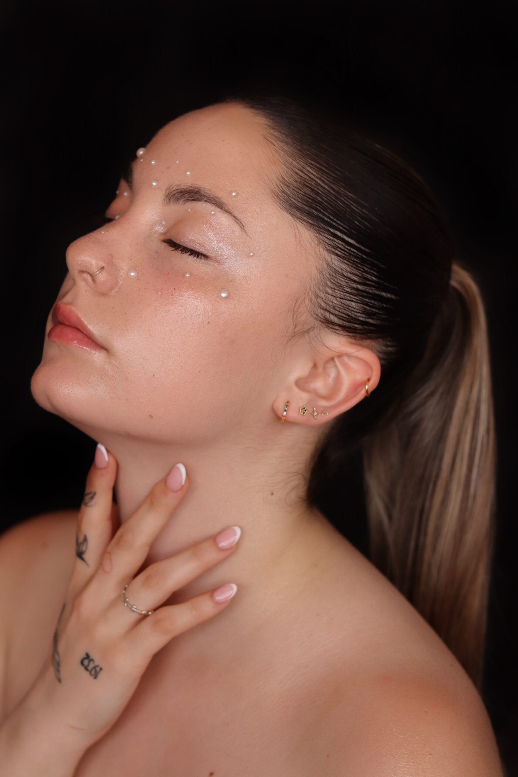 a woman in glasses applying a makeup product